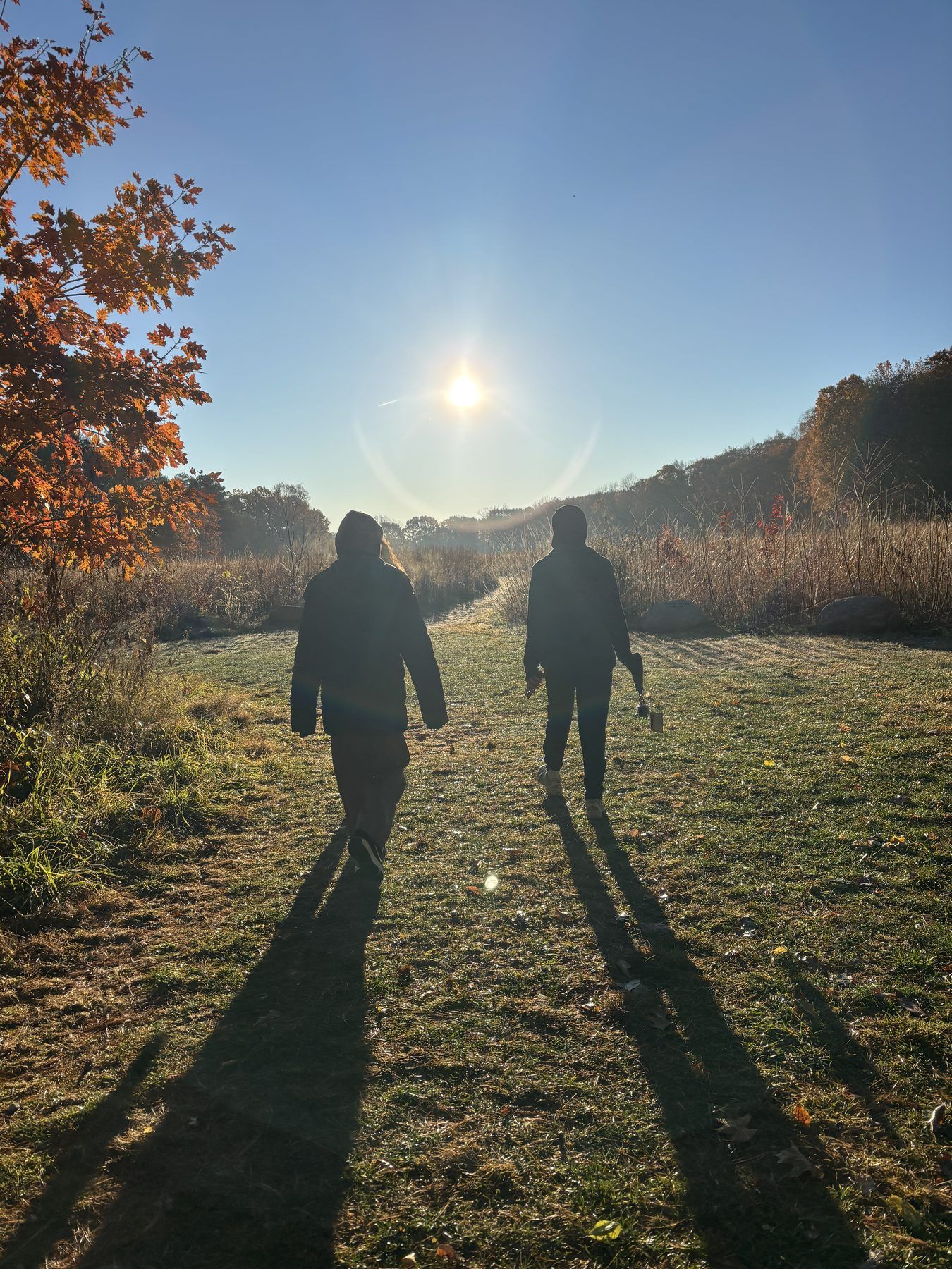 Two ISA members walking through a field at sunset