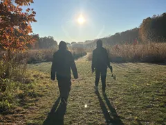 Two ISA members walking through a field at sunset